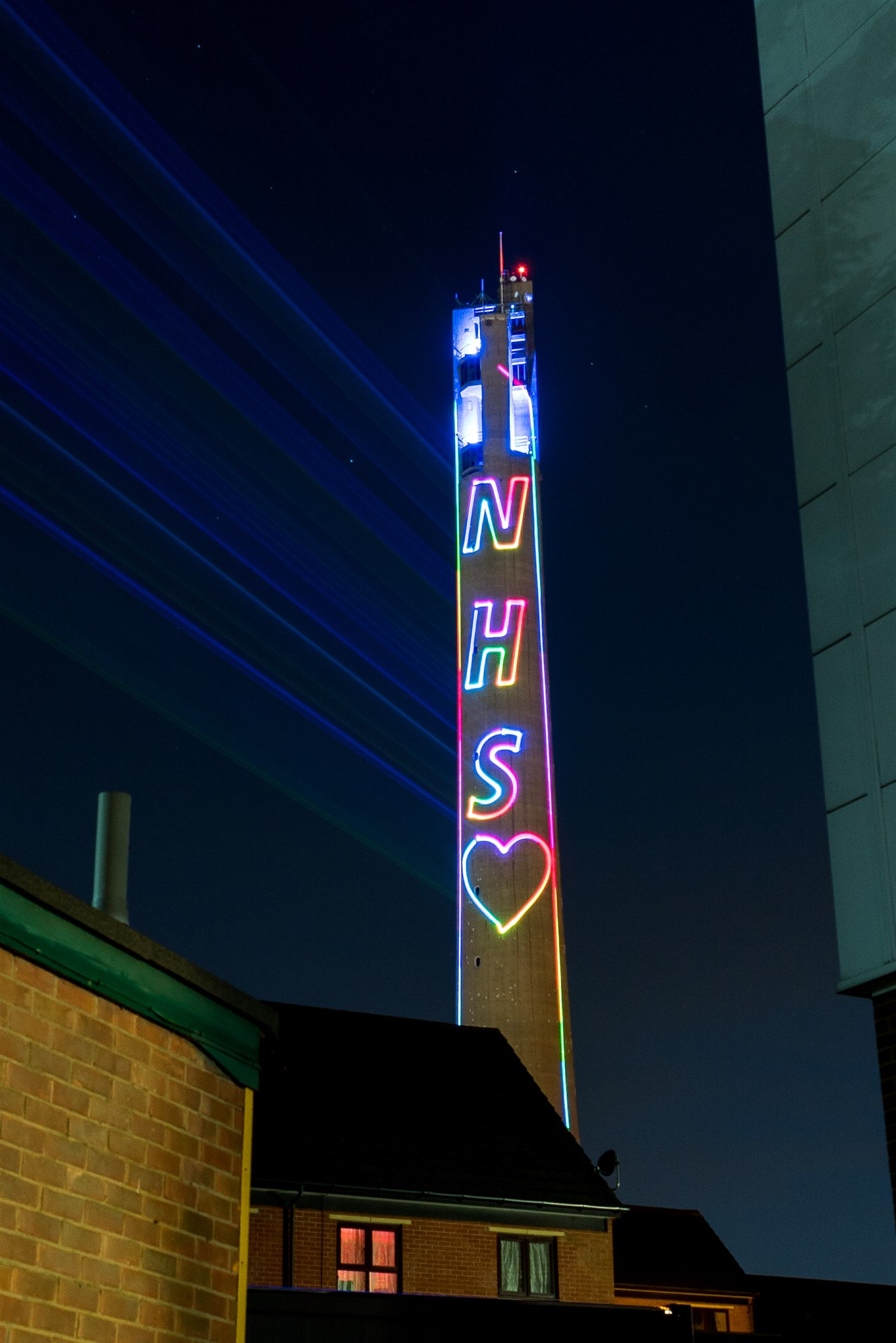 Multicoloured NHS lettering and a heart projected on the Lift Tower